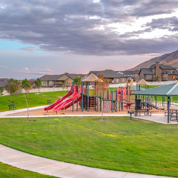 Cloudy sky over playground in Saratoga Springs UT. Cloudy sky over a playground with eating area for the children in Saratoga Springs, Utah. Homes and mountain can be seen in the background.